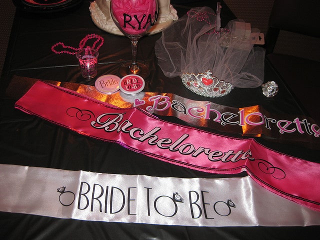 Sashes, a tiara, beaded necklaces and other various bachelorette props